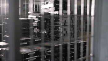 Stacks of computer hard drives are shown inside of a metal cage.